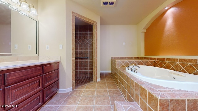 bathroom with tile patterned flooring, vanity, and separate shower and tub