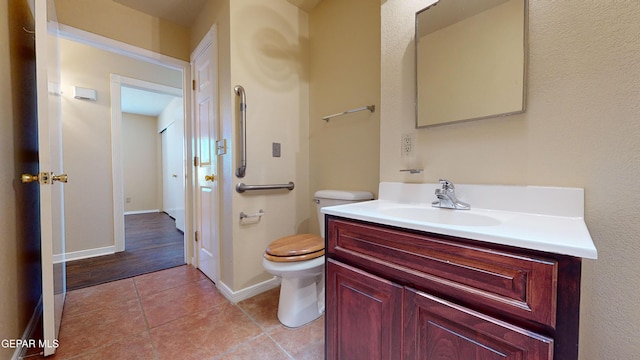 bathroom featuring tile patterned flooring, vanity, and toilet