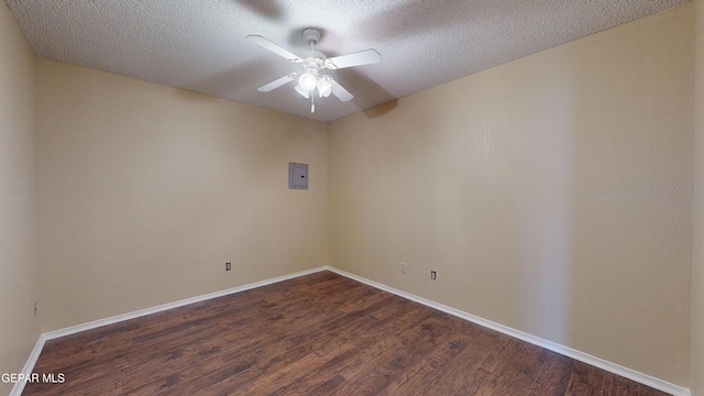 unfurnished room featuring electric panel, ceiling fan, dark wood-type flooring, and a textured ceiling