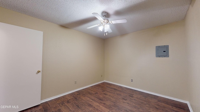 unfurnished room with ceiling fan, dark hardwood / wood-style flooring, a textured ceiling, and electric panel