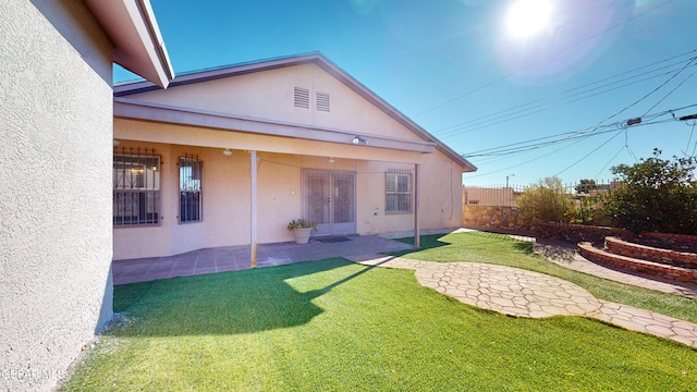 back of property featuring a lawn and a patio