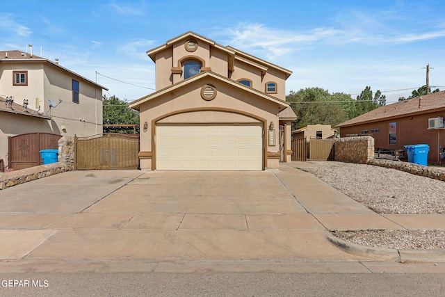 view of front facade with stucco siding, a garage, driveway, and a gate