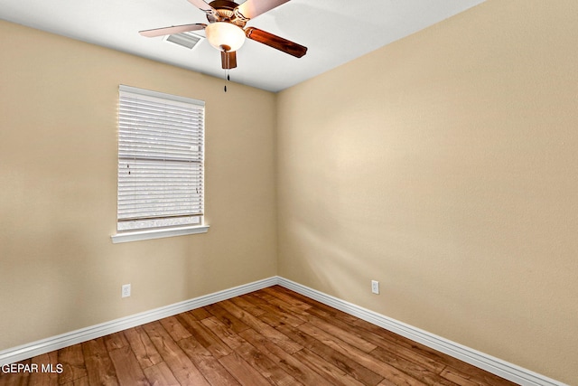 empty room with a ceiling fan, wood finished floors, and baseboards