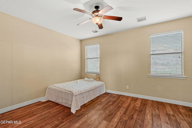 bedroom featuring hardwood / wood-style flooring, baseboards, and visible vents