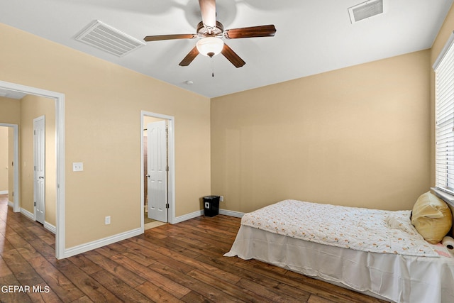 bedroom with dark wood-style floors, visible vents, and baseboards