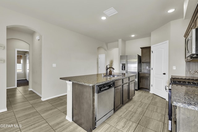 kitchen with a sink, visible vents, arched walkways, and appliances with stainless steel finishes