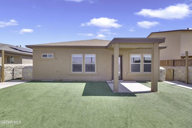 back of property featuring stucco siding and a lawn