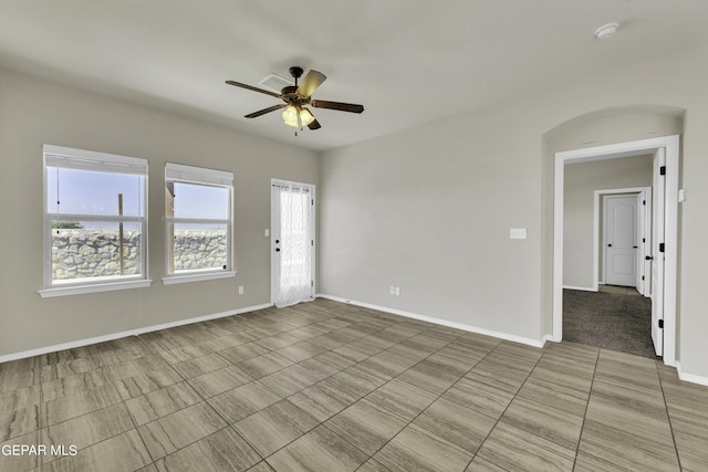 spare room with baseboards and a ceiling fan