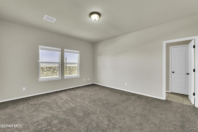 unfurnished room with visible vents, baseboards, and carpet