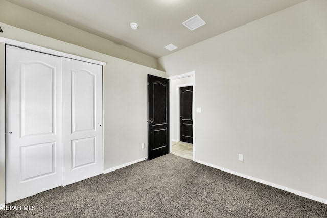 unfurnished bedroom with visible vents, baseboards, light colored carpet, and a closet