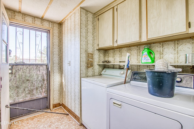 laundry area featuring a textured ceiling, cabinets, and washer and dryer