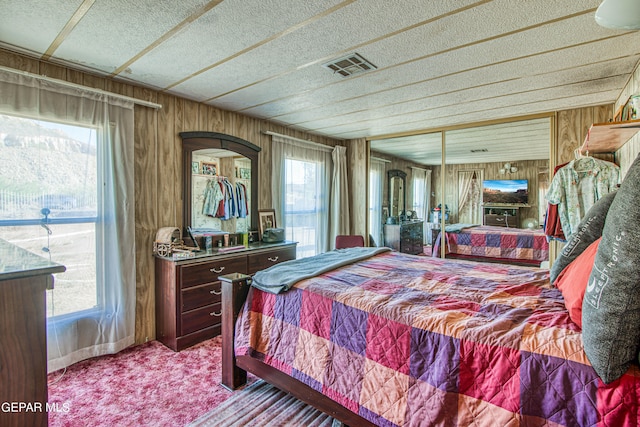 carpeted bedroom with wooden walls