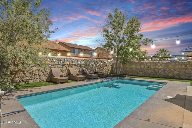 view of pool at dusk