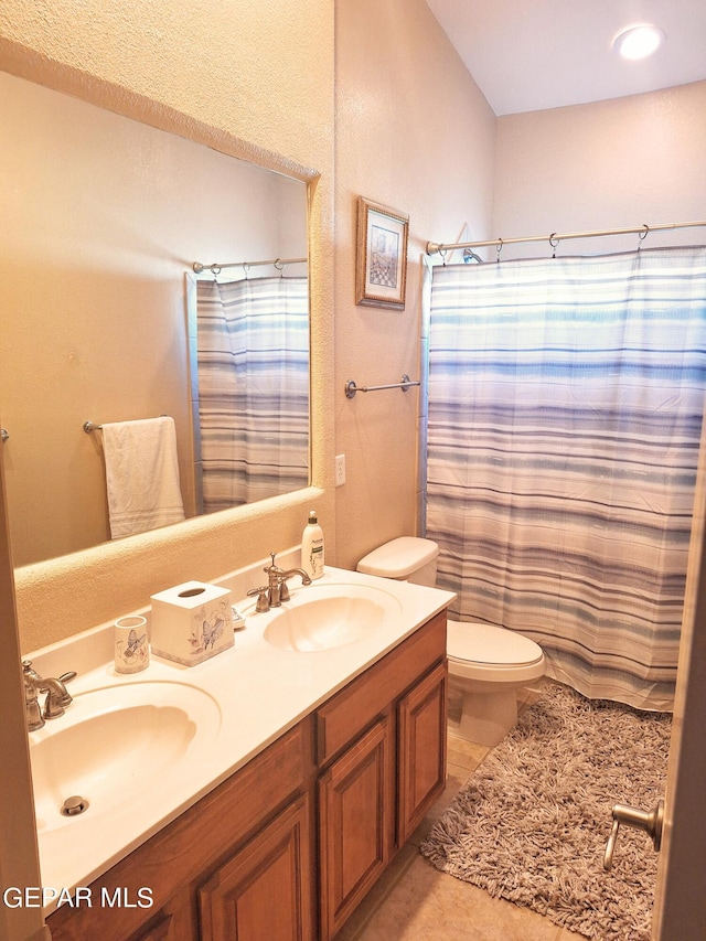 bathroom featuring toilet, curtained shower, vanity, and tile patterned floors