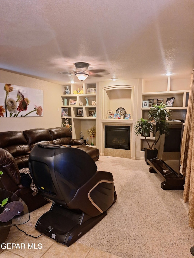 living room with built in shelves, a textured ceiling, and ceiling fan