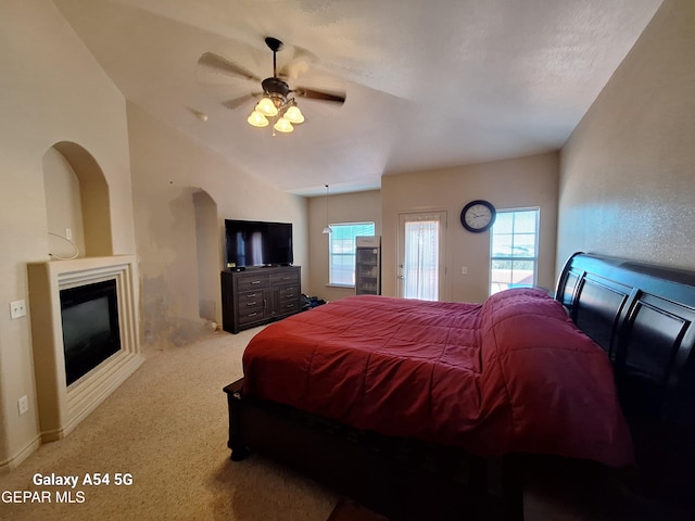 bedroom featuring a textured ceiling, vaulted ceiling, light colored carpet, and ceiling fan