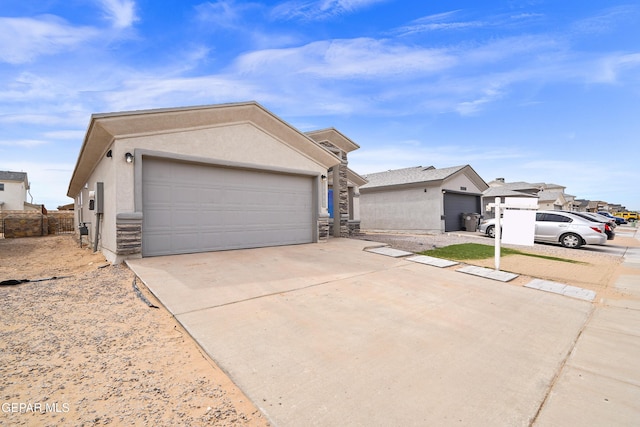 view of front of house with stucco siding, a garage, and driveway