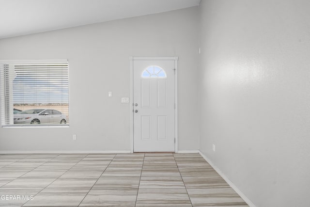 entrance foyer featuring baseboards and lofted ceiling