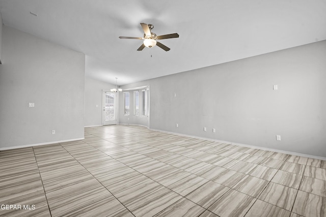 unfurnished room featuring ceiling fan with notable chandelier and baseboards