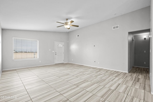 unfurnished room featuring visible vents, baseboards, ceiling fan, and vaulted ceiling