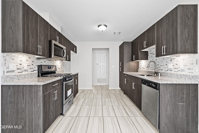 kitchen with a sink, visible vents, appliances with stainless steel finishes, and dark brown cabinets