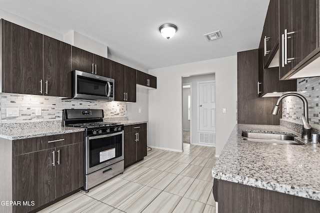 kitchen featuring a sink, visible vents, dark brown cabinetry, and appliances with stainless steel finishes