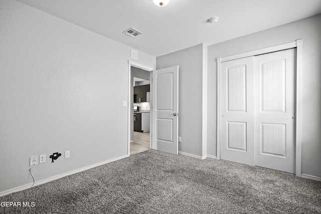 unfurnished bedroom featuring a closet, visible vents, carpet flooring, and baseboards