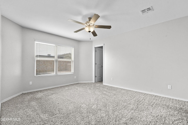 empty room with a ceiling fan, visible vents, carpet floors, and baseboards