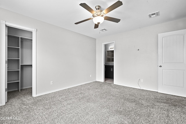 unfurnished bedroom with visible vents, a spacious closet, a closet, and carpet flooring