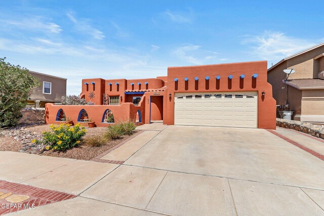 pueblo revival-style home with a garage