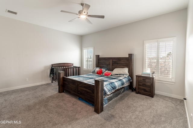 bedroom featuring multiple windows, ceiling fan, and light carpet