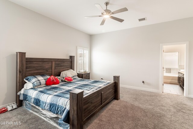 bedroom featuring light carpet, connected bathroom, and ceiling fan