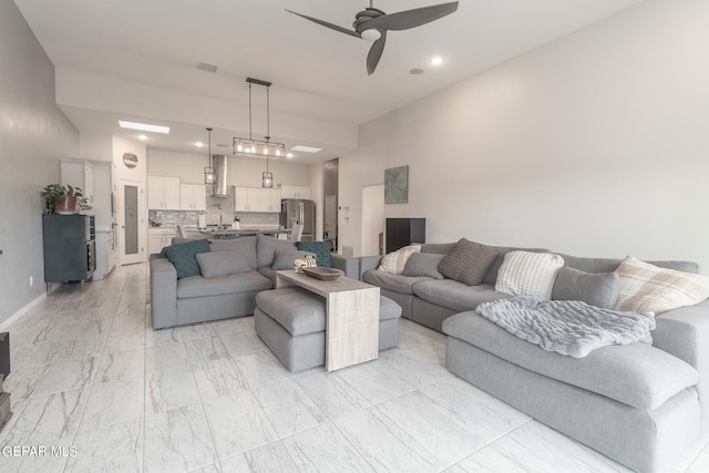 living room featuring baseboards, marble finish floor, and ceiling fan