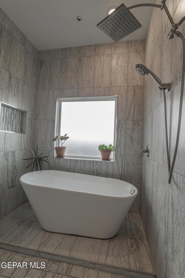 bathroom featuring tile walls and independent shower and bath