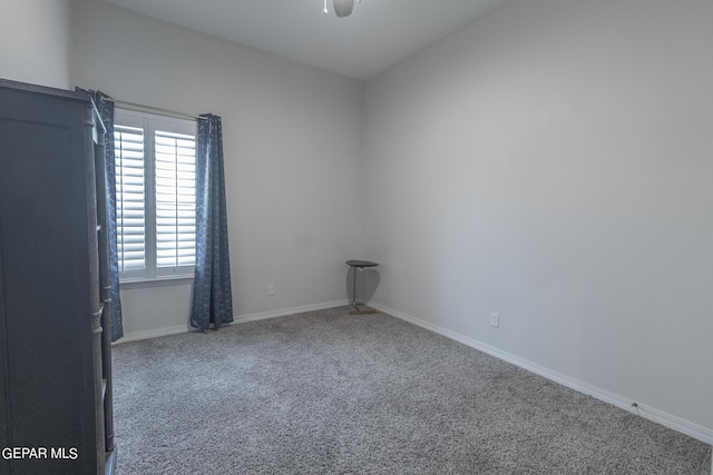 empty room with carpet, a ceiling fan, and baseboards