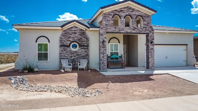 view of front of property with a tile roof, concrete driveway, stucco siding, stone siding, and an attached garage