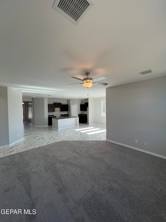 unfurnished living room featuring light colored carpet and ceiling fan