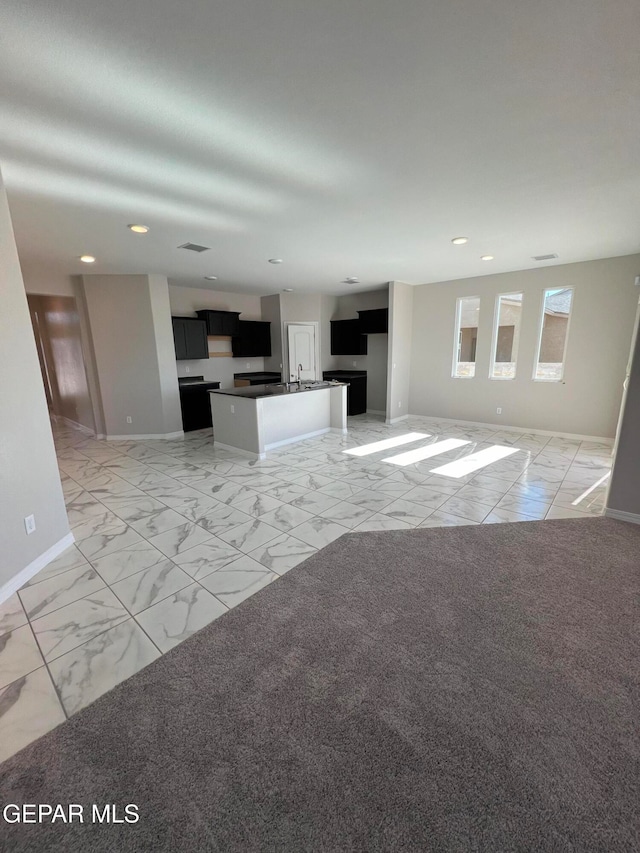 unfurnished living room featuring sink