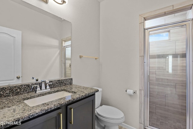 bathroom featuring an enclosed shower, toilet, plenty of natural light, and vanity