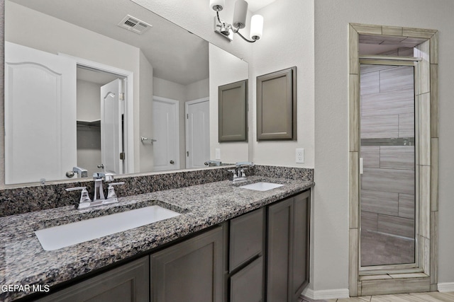 bathroom with vanity, an inviting chandelier, and an enclosed shower