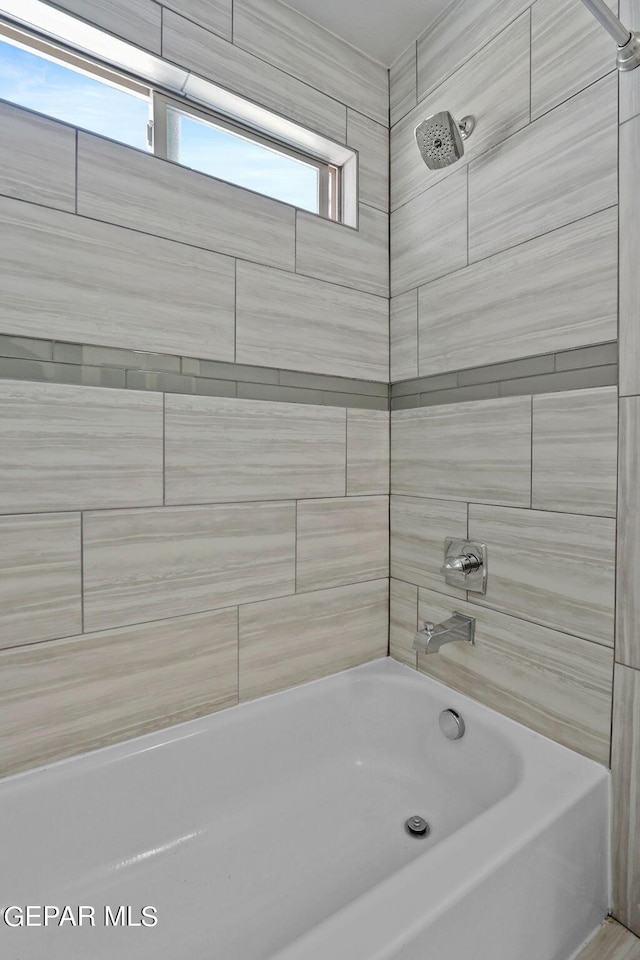 bathroom featuring tiled shower / bath