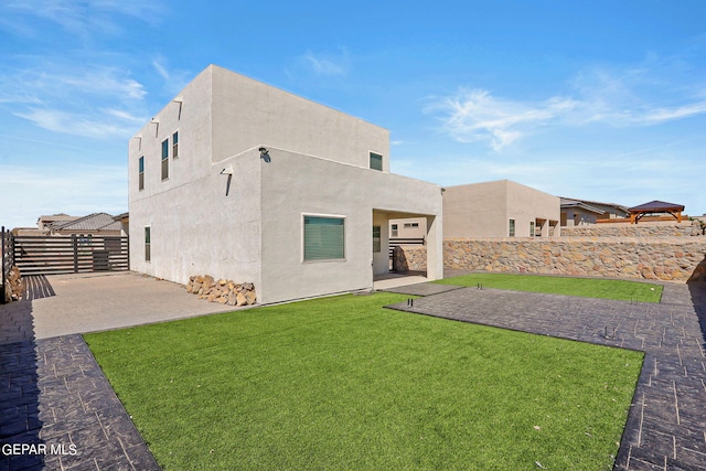 back of property featuring a yard and a patio