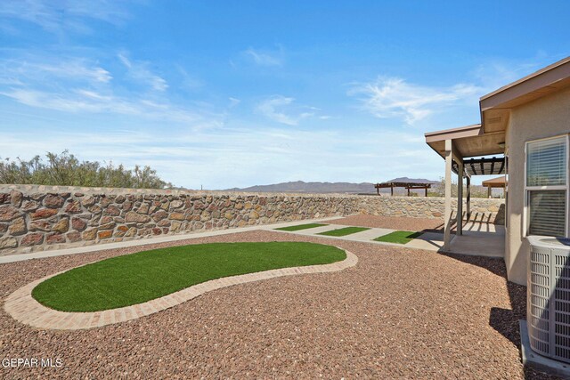 view of yard with central AC unit and a patio