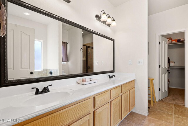 bathroom featuring tile patterned flooring, vanity, and walk in shower