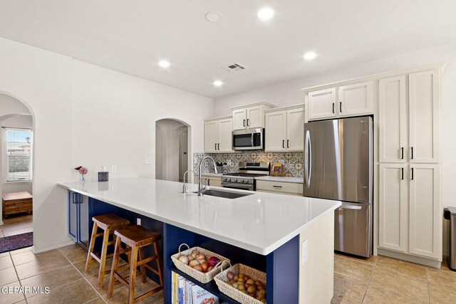 kitchen with white cabinets, a kitchen breakfast bar, stainless steel appliances, and kitchen peninsula