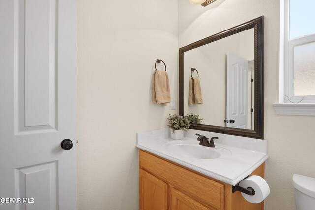 bathroom featuring a wealth of natural light, vanity, and toilet