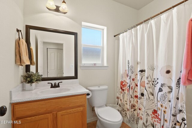 bathroom featuring vanity, toilet, and walk in shower