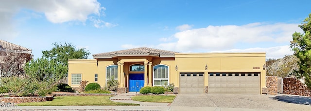 mediterranean / spanish-style house featuring a garage and a front yard