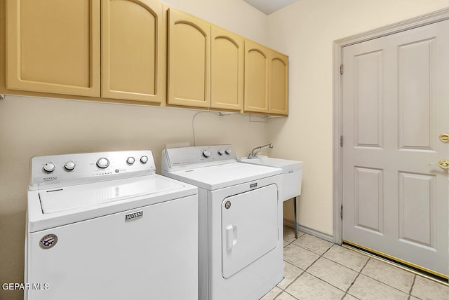 clothes washing area featuring light tile patterned flooring, separate washer and dryer, and cabinets