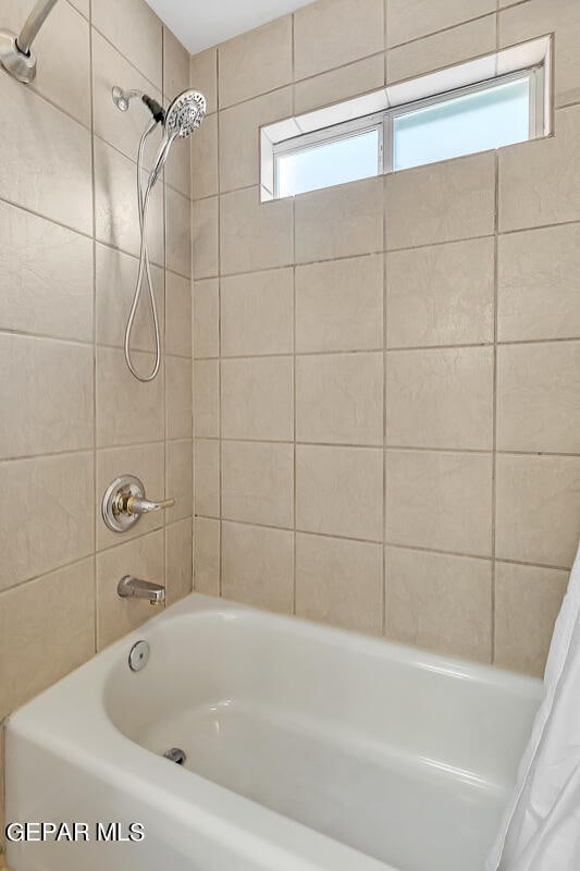 bathroom with shower / bath combination with curtain and plenty of natural light